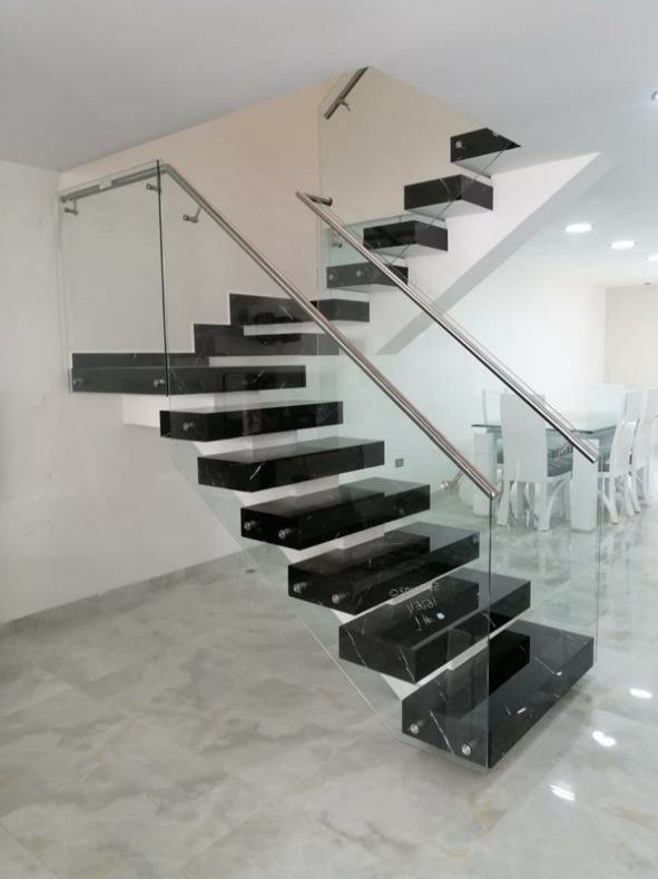 Escalera flotante en mármol negro con pasamanos en acero inoxidable